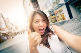Premium Photo | Happy asian woman excited with thumb up taking selfie in  city street